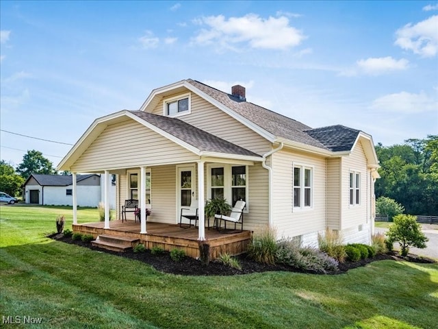 back of property with covered porch and a yard