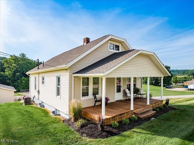 back of house with cooling unit and a lawn