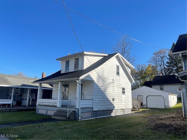 view of side of home featuring a yard, a porch, an outbuilding, and a garage