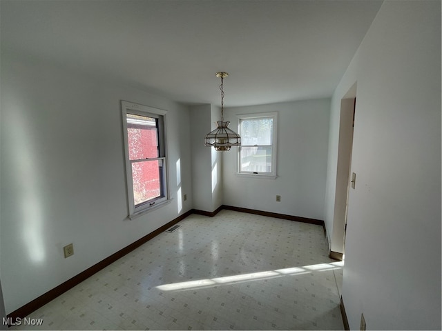 unfurnished dining area with an inviting chandelier and plenty of natural light