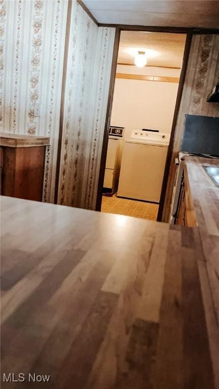 hallway with washing machine and dryer and wooden walls