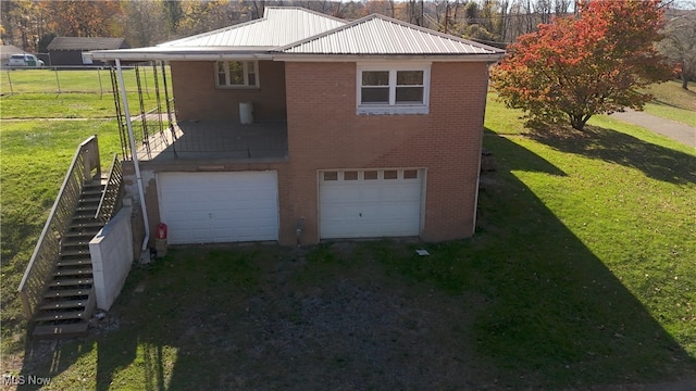 exterior space featuring a garage and a lawn