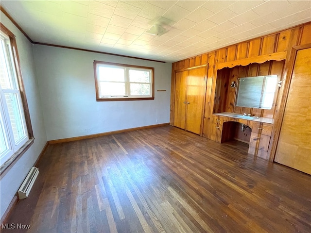 interior space featuring ornamental molding, wood walls, sink, and dark wood-type flooring