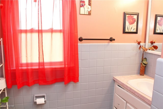 bathroom with vanity and tile walls