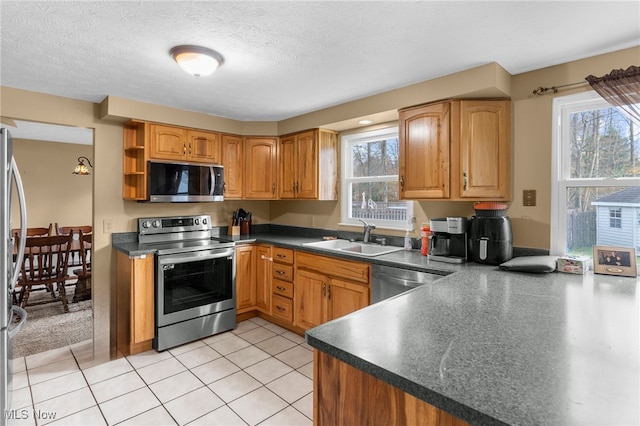 kitchen featuring a healthy amount of sunlight, sink, a textured ceiling, and appliances with stainless steel finishes