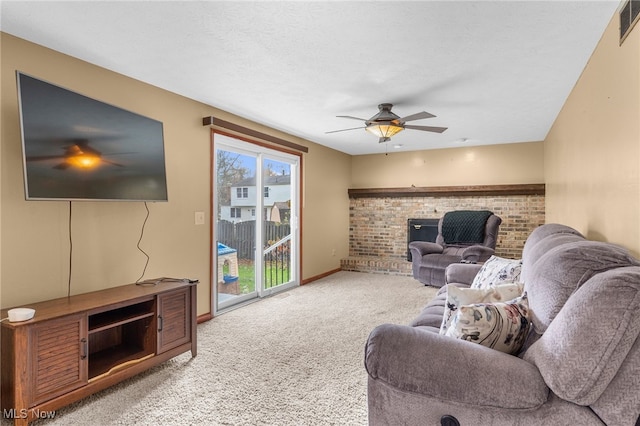 carpeted living room with a textured ceiling, a brick fireplace, and ceiling fan