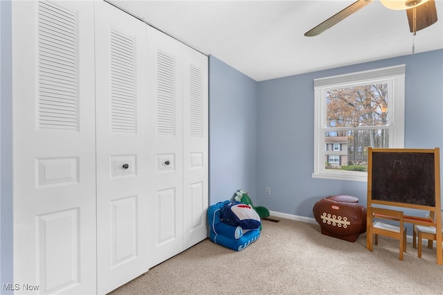 sitting room featuring carpet and ceiling fan