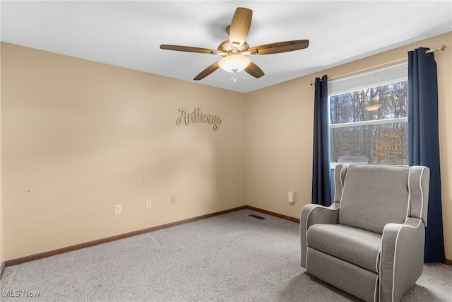 living area with carpet floors and ceiling fan