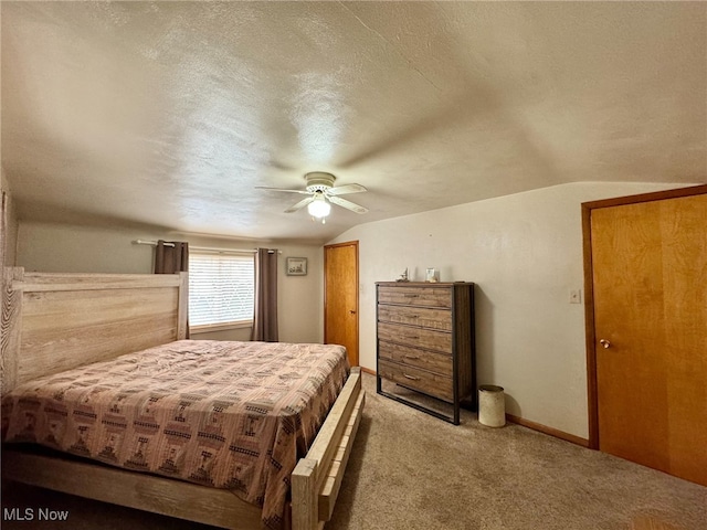 carpeted bedroom with lofted ceiling, ceiling fan, and a textured ceiling