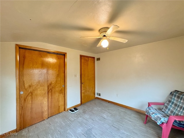 unfurnished bedroom with ceiling fan, lofted ceiling, and a closet