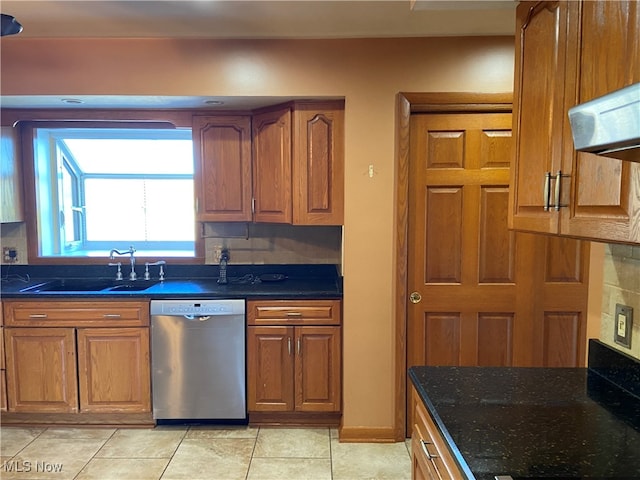 kitchen with tasteful backsplash, light tile patterned flooring, range hood, dark stone countertops, and stainless steel dishwasher