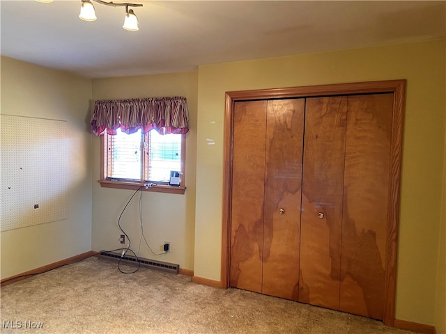 unfurnished bedroom with a closet, light carpet, and a baseboard radiator