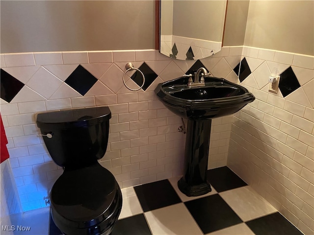 bathroom with tile walls and toilet