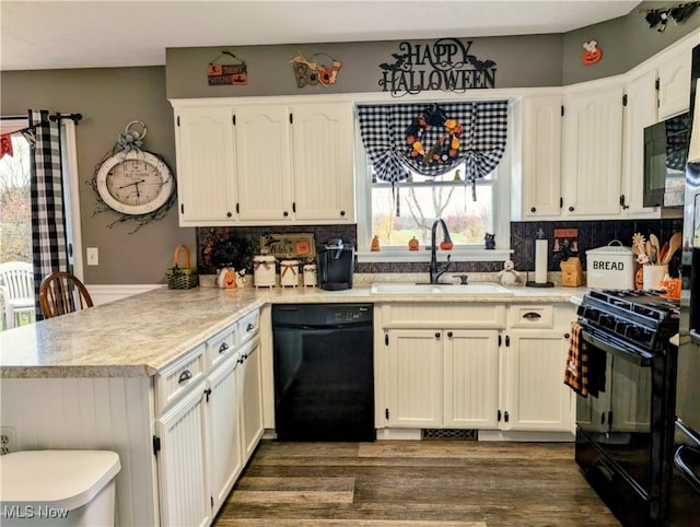 kitchen with black appliances, backsplash, dark hardwood / wood-style flooring, sink, and kitchen peninsula