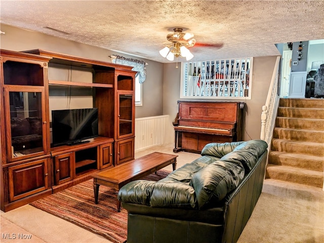 living room featuring light carpet, a textured ceiling, and ceiling fan