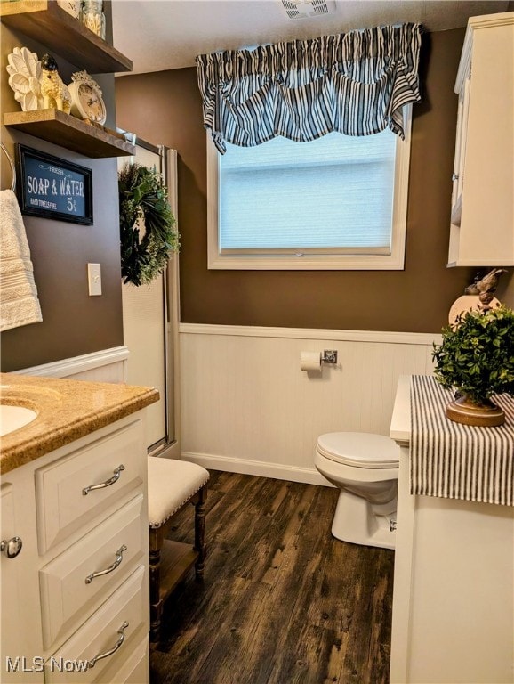 bathroom with toilet, vanity, and hardwood / wood-style flooring