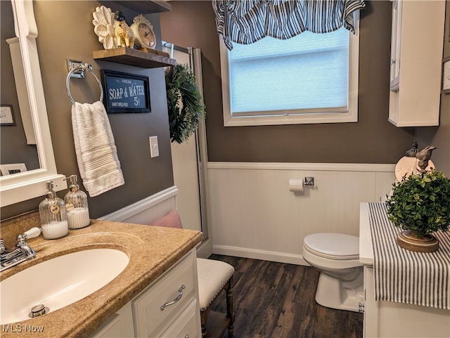 bathroom with hardwood / wood-style floors, vanity, and toilet