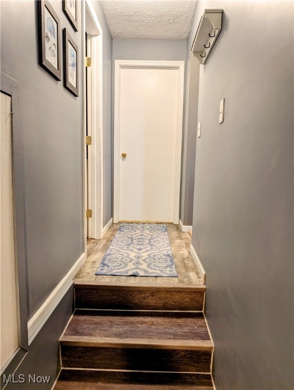 stairs featuring a textured ceiling