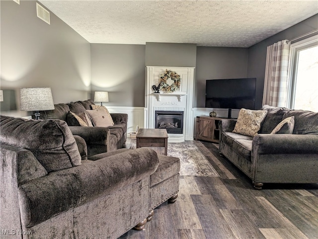 living room with a textured ceiling and dark hardwood / wood-style floors