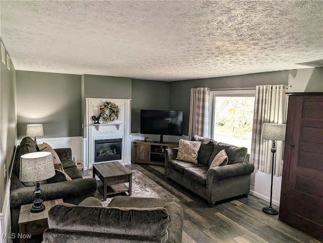 living room featuring a textured ceiling and dark hardwood / wood-style floors