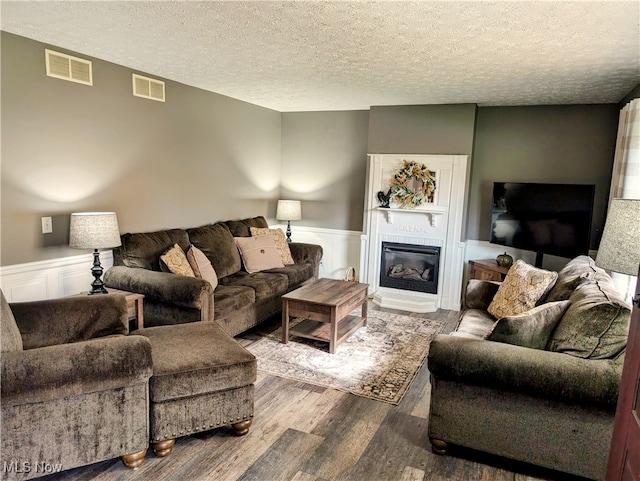 living room with wood-type flooring and a textured ceiling