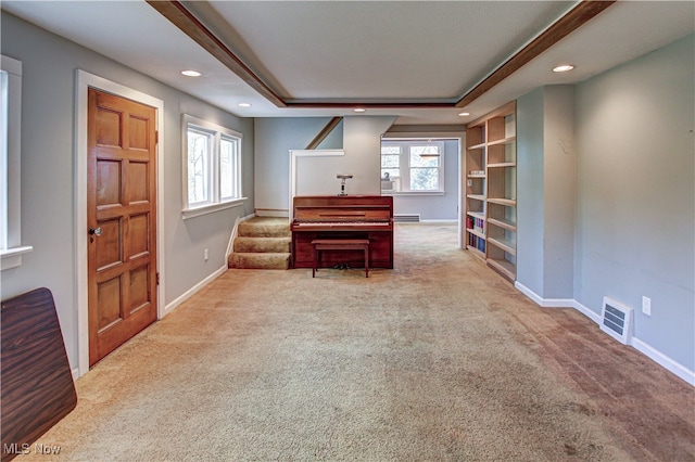 misc room featuring carpet flooring and a tray ceiling