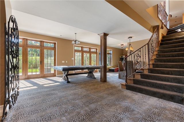 game room with carpet flooring, an inviting chandelier, decorative columns, and french doors