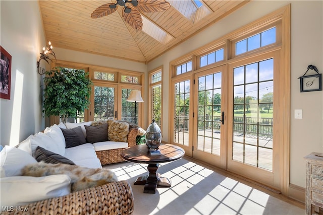 sunroom / solarium featuring vaulted ceiling with skylight, ceiling fan, and wood ceiling