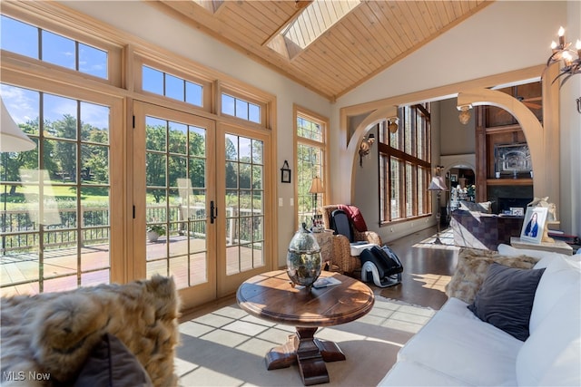 sunroom featuring french doors, lofted ceiling with skylight, and wooden ceiling