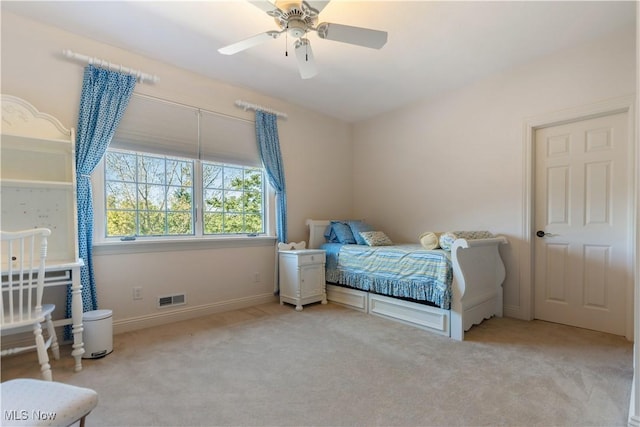 carpeted bedroom with visible vents, a ceiling fan, and baseboards