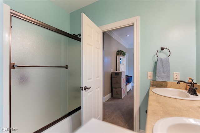 bathroom featuring a shower with door, vanity, and ornamental molding