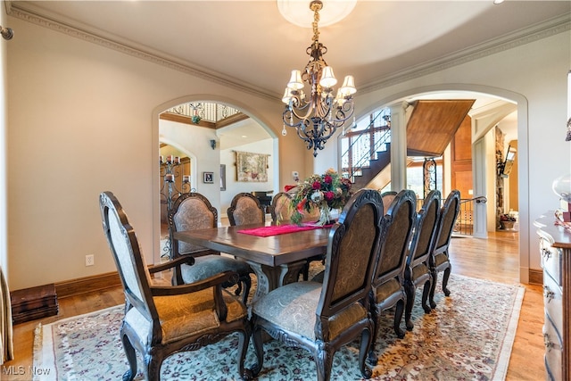 dining room with a chandelier, light wood-type flooring, and ornamental molding