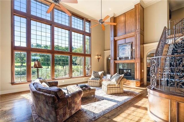 living room featuring plenty of natural light, light hardwood / wood-style floors, a fireplace, and a high ceiling