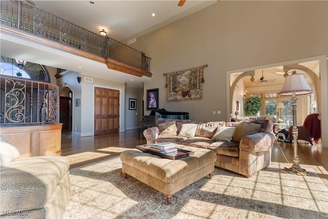 living room with arched walkways, ceiling fan, and wood finished floors