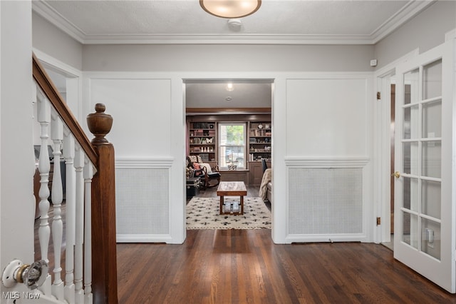 interior space featuring dark wood-type flooring, crown molding, and a textured ceiling