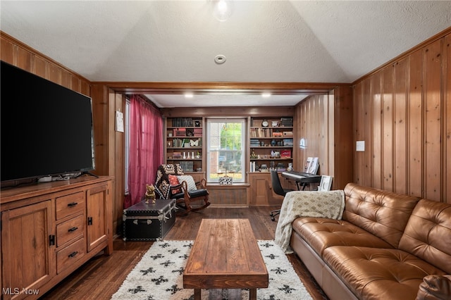 living room featuring wood walls, built in features, a textured ceiling, and dark hardwood / wood-style floors