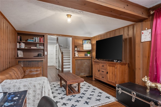 living room with a textured ceiling, dark hardwood / wood-style floors, wooden walls, and vaulted ceiling