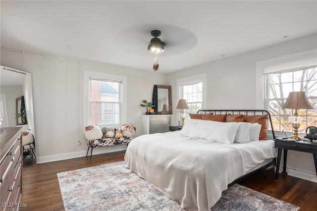 bedroom with dark wood-type flooring, multiple windows, and ceiling fan