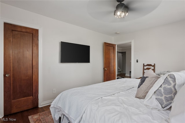 bedroom with dark hardwood / wood-style floors and ceiling fan