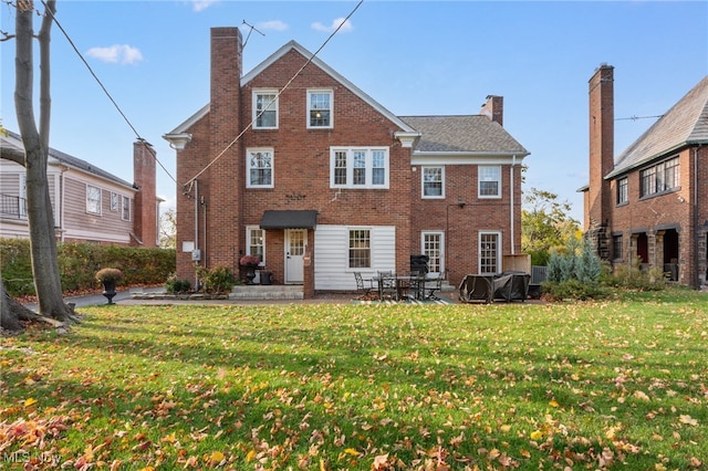 rear view of property featuring a yard and a patio