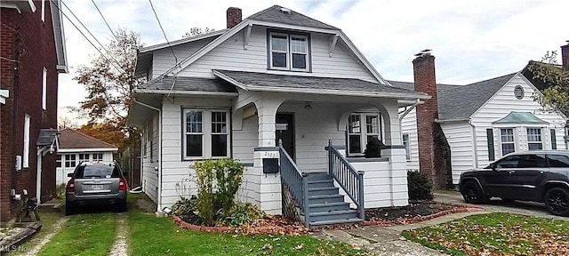 2322 Walnut Blvd, Ashtabula, OH 44004 - bungalow-style house featuring covered porch, roof with shingles, a chimney, and a front yard
