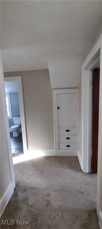 corridor with carpet and a textured ceiling