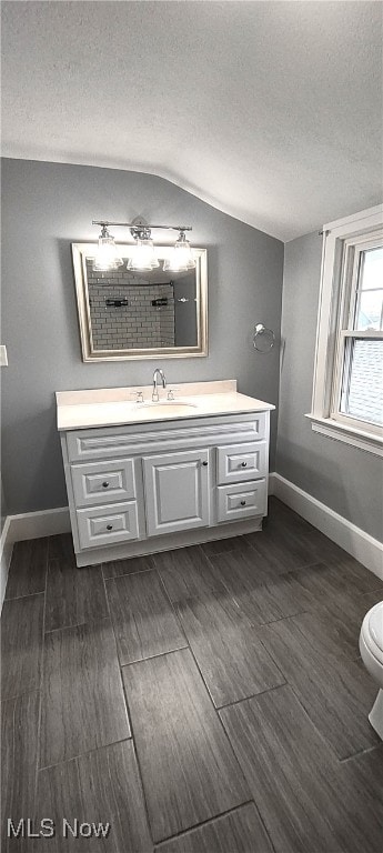 bathroom featuring hardwood / wood-style flooring, vanity, lofted ceiling, and toilet