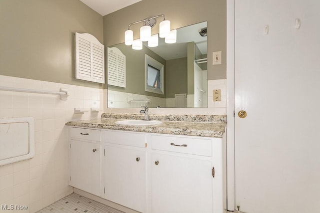 bathroom featuring tile patterned flooring, vanity, and tile walls