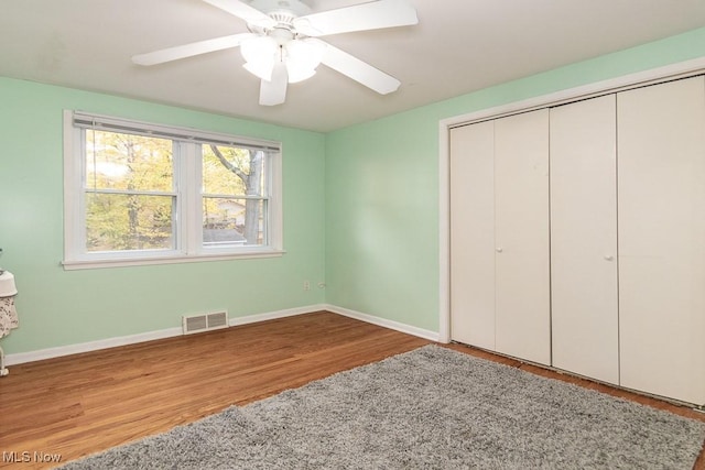 unfurnished bedroom with light wood-type flooring, a closet, and ceiling fan