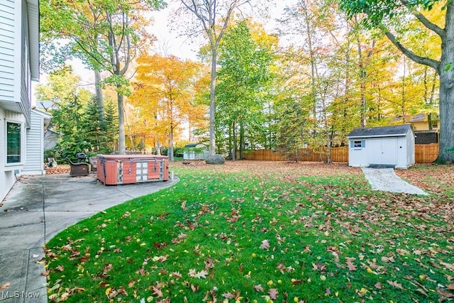 view of yard featuring a patio area, a storage shed, and a hot tub