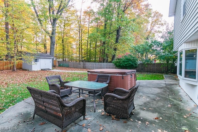 view of patio / terrace with a hot tub and a storage shed