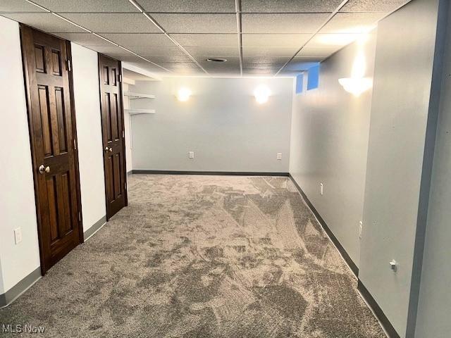 basement with a drop ceiling and carpet floors