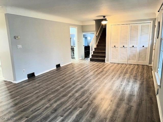 unfurnished living room featuring dark wood-type flooring