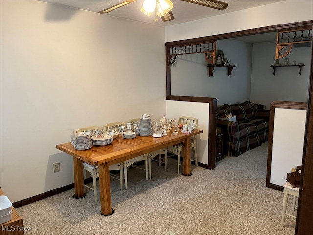 carpeted dining room with ceiling fan